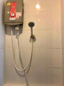 a hose hooked up to a dispenser on a wall at Kata Beach Guesthouse in Kata Beach