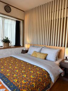 a bedroom with a large bed with a large window at 熱海天海ヴィラ/ Atami Tenkai Villa in Atami