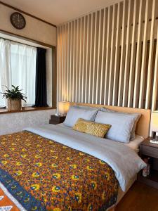 una camera da letto con un letto grande con una grande finestra di 熱海天海ヴィラ/ Atami Tenkai Villa ad Atami Altre 21 foto
