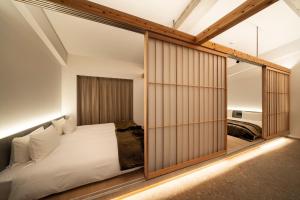 a bedroom with a bed and sliding glass doors at Kyoto ITOYA Hotel Mon 京都糸屋ホテル モン in Kyoto