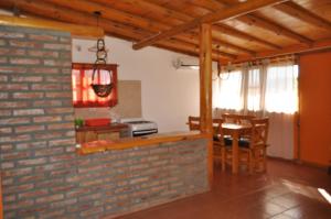 cocina y comedor con pared de ladrillo en la martina en Villa Giardino