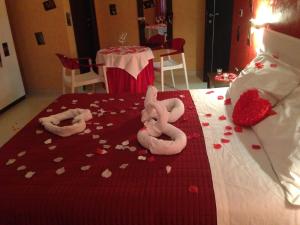 two stuffed animals laying on a bed with hearts at B&B 21-12 in Saviano