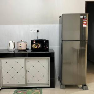 uma cozinha com um micro-ondas e um frigorífico em Homestay Ayer Keroh Tasik Utama em Ayer Keroh