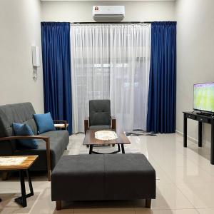 sala de estar con sofá, TV y cortinas azules en Homestay Ayer Keroh Tasik Utama en Ayer Keroh