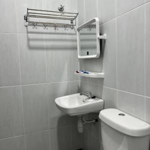 bagno con lavandino, servizi igienici e specchio di Homestay Ayer Keroh Tasik Utama ad Ayer Keroh