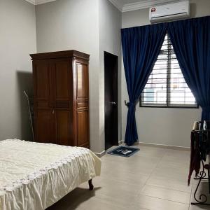 1 dormitorio con 1 cama, vestidor y ventana en Homestay Ayer Keroh Tasik Utama, en Ayer Keroh