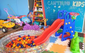 una sala de juegos infantil llena de juguetes y una piscina de pelotas en Pousada Enseada São Miguel de frente para o mar, en Penha