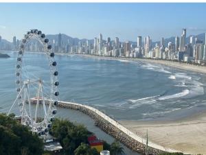 una gran noria en una playa junto a una ciudad en frente mar, espetacular vista mar, roda gigante, en Balneário Camboriú