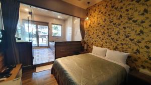 1 dormitorio con 1 cama con pared de flores en Wulai Shui An Hot Springs, en Wulai