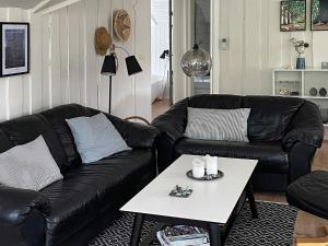 Hemmetにある6 person holiday home in Hemmetのリビングルーム(黒い革張りのソファ、テーブル付)