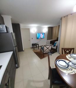 eine Küche und ein Wohnzimmer mit einem Tisch und einem Esszimmer in der Unterkunft DEPARTAMENTO EDIFICIO AZUL I in Iquique