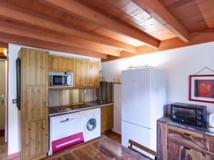 a kitchen with a white refrigerator and a microwave at Chalet Mitoyen 3 Chambres, Terrasse, Proche Centre Cauterets, Navette Ski Gratuite - FR-1-401-254 in Cauterets