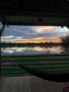 a hammock under a pavilion with a view of a lake at Vera Sunset homestay local experience with lao family in Muang Không