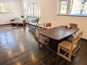 a room with a large wooden table and chairs at 暮らす宿ソラプチ Sorapchi Cabin 