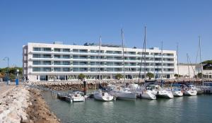 un grande edificio bianco con barche ormeggiate in un porto turistico di Suites Puerto Sherry a El Puerto de Santa María