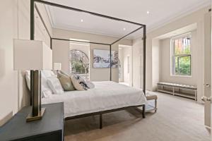 - une chambre avec un grand lit et un grand miroir dans l'établissement The Kirribilli, à Sydney
