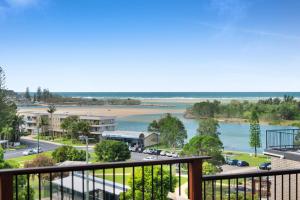 a balcony with a view of a beach and a street at The Beach Rooms in Nambucca Heads