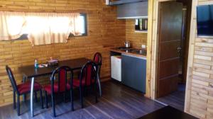 a kitchen with a table and chairs in a room at Cabañas El Druida in Villa General Belgrano
