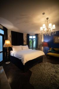 a bedroom with a large bed and a chandelier at Baan Tuk Din Hotel in Bangkok