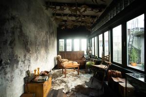a room with a table and chairs and windows at Baan Tuk Din Hotel in Bangkok +78 photos