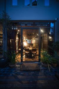 a dining room with a table inside of a house at night at Baan Tuk Din Hotel in Bangkok