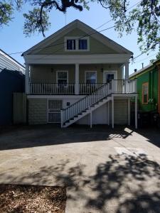 a house with a porch and a staircase in front of it at Troy's Place in New Orleans