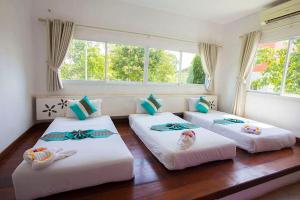 three beds in a room with windows at Aurora Resort Khao Yai in Mu Si