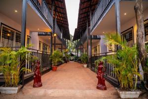 a corridor of a building with potted plants at The Riverside in Mandrem