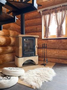 uma sala de estar com lareira num chalé de madeira em Medveď, Vlk, Líška Zrubová rozprávka nad rybníkom em Kostolná Ves