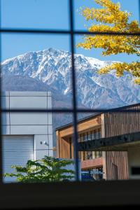 a view of a snow covered mountain through a window at 赤だすき_別邸 in Hakuba