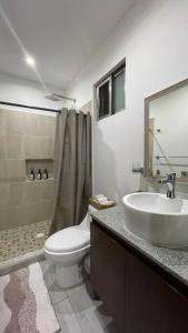 a bathroom with a sink and a toilet and a shower at Cancun Lucky & Friendly Condo in Cancún
