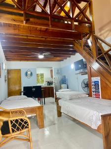 Habitación con 2 camas, mesa y cocina. en Cabaña Diana, en San Andrés