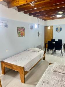 1 dormitorio con 1 cama, mesa y sillas en Cabaña Diana, en San Andrés