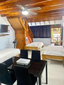 a room with two beds and a table and chairs at Cabaña Diana in San Andrés