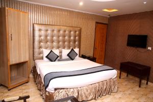 a hotel room with a large bed and a television at Premier inn Mall Lahore in Lahore