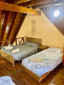 two beds in a attic room with wooden ceilings at Cabaña Diana in San Andrés