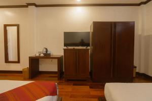 a room with a television and a large brown cabinet at Lux Hotel in Luang Prabang