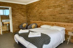 1 Schlafzimmer mit 2 Betten und Ziegelwand in der Unterkunft Deepwater Hotel in Deepwater