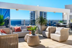 a patio with couches and chairs on a roof at Biarritz Apartments in Gold Coast