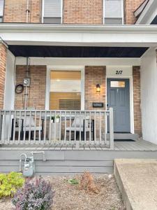 a house with a porch with two chairs and a door at The Clemente Mt. Washington by Luxe PGH in Pittsburgh