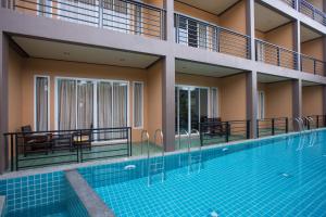 a swimming pool in the middle of a building at Khaolak Suthawan Resort - SHA Plus in Khao Lak