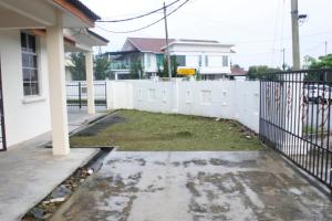 a yard in front of a white fence at Homestay Mokde in Muar