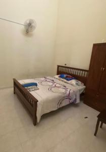a bedroom with a bed with a lamp and a dresser at Homestay Mokde in Muar