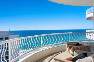 a balcony with chairs and the ocean in the background at Biarritz Apartments in Gold Coast