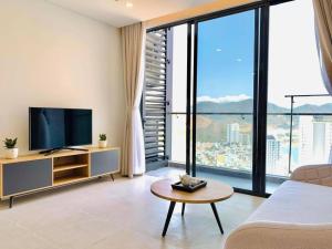 a living room with a tv and a large window at Wise Stay Scenia Bay Apartment in Nha Trang