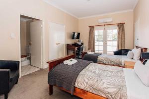 a hotel room with two beds and a desk at Settlers Hotel York in York