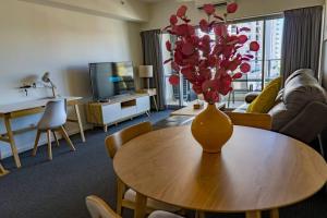 uma sala de estar com uma mesa com um vaso de flores em Pandanas Apt 1 (U will love it) em Darwin