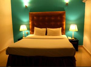 a bedroom with a large bed with two lamps at Premier inn Mall Lahore in Lahore