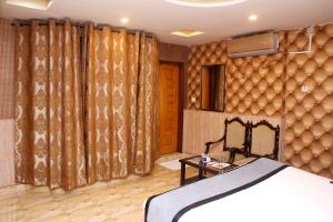 ein Schlafzimmer mit einem Bett und einer Wand mit Vorhängen in der Unterkunft Premier inn Mall Lahore in Lahore
