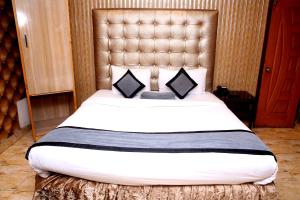 a bedroom with a large bed with a large headboard at Premier inn Mall Lahore in Lahore